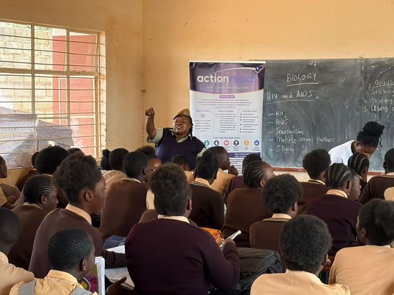 Pupils seated in a classroom with an information poster beside the blackboard